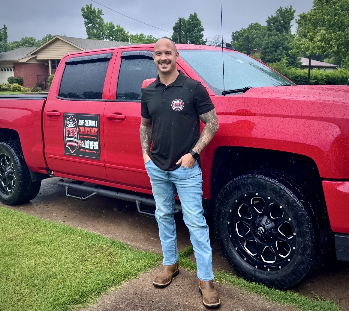 Kyle Brooks, owner of First In Response Exteriors, standing beside the company truck