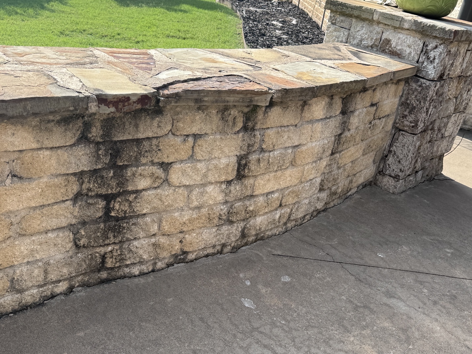 Stone patio wall before exterior cleaning