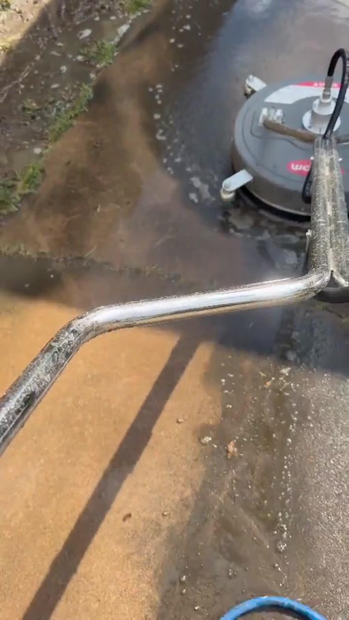 Kyle using a professional surface cleaner during a concrete-cleaning job
